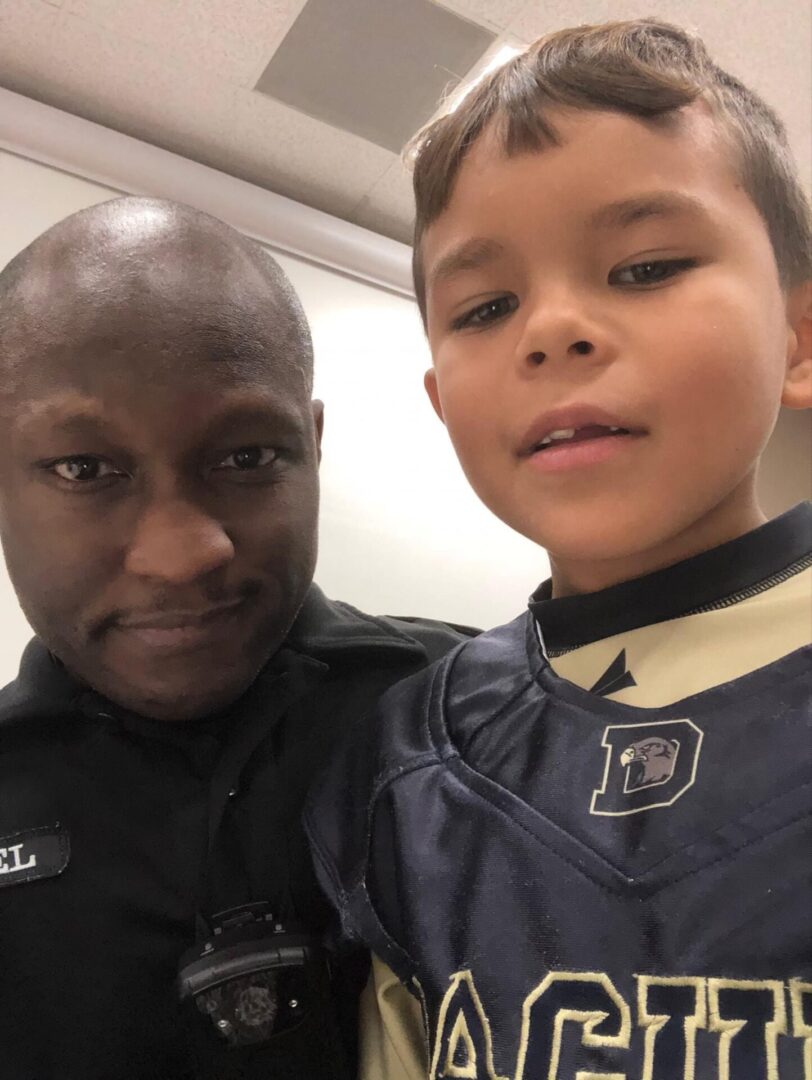 A police officer and a young boy posing for the camera.