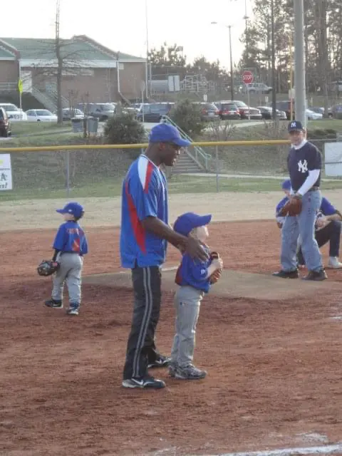 A man and boy in blue baseball uniforms.